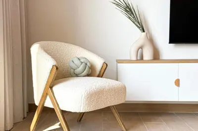 a chair in a living room next to a desk at HiGuests - Coastal Chic Luxurious Retreat at Port de la Mer in Dubai
