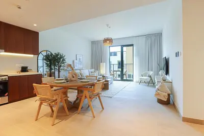 a kitchen and living room with a table and chairs at HiGuests - Coastal Chic Luxurious Retreat at Port de la Mer in Dubai