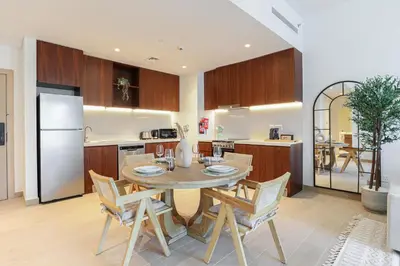 a kitchen with a table and chairs and a refrigerator at HiGuests - Coastal Chic Luxurious Retreat at Port de la Mer in Dubai