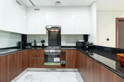 a kitchen with white cabinets and a stove top oven at Vacay Lettings 1 bed Business home in J One Tower Business bay in Dubai