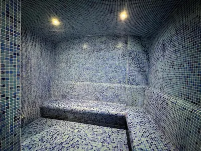 a blue tiled bathroom with a bath tub with lights at Naseem - Studio One Tower in Dubai