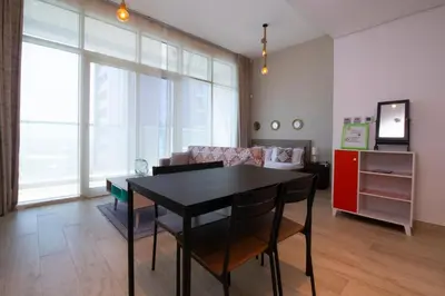a living room with a black table and chairs at Naseem - Studio One Tower in Dubai
