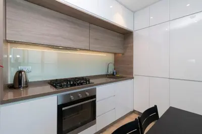 a kitchen with white cabinets and a stove at Naseem - Studio One Tower in Dubai