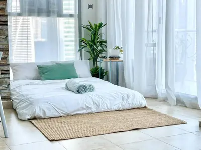 a bed in a room with a large window at Jlt Spacious Corner Duplex Loft Panoramic Views in Dubai