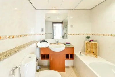 a bathroom with a sink and a toilet and a tub at Jlt Spacious Corner Duplex Loft Panoramic Views in Dubai