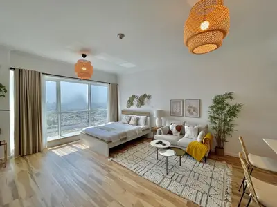 a living room with a couch and a table at Spacious Jlt High Floor Studio Wstunning Views in Dubai