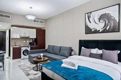 a bedroom with a large bed and a couch at Newly Built Studio - Comfort in Dubai