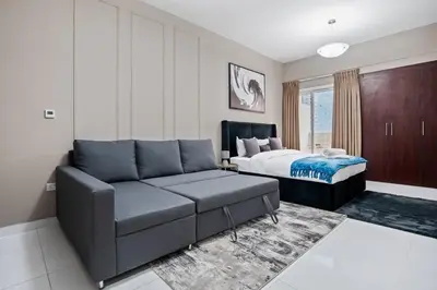 a living room with a couch and a bed at Newly Built Studio - Comfort in Dubai