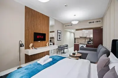 a bedroom with a large bed and a living room at Newly Built Studio - Comfort in Dubai