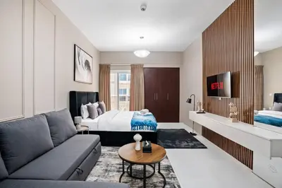 a living room with a couch and a bed at Newly Built Studio - Comfort in Dubai