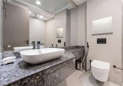 a bathroom with a white sink and a toilet at HAVN - Studio Apartment in Chaimaa Avenue, JVC in Dubai