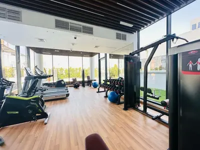 a gym with treadmills and exercise equipment in a building at HAVN - Studio Apartment in Chaimaa Avenue, JVC in Dubai