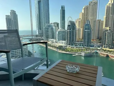 a table and chair on a balcony with a view of a city at Casa Royale Vacation Home - Dubai Marina in Dubai