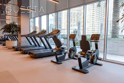 a row of treadmills in a gym with large windows at Forte Tower by Emaar, Downtown Dubai in Dubai
