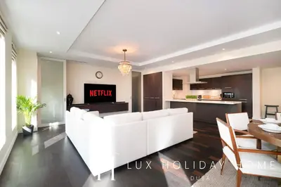 a living room with a white couch and a kitchen at LUX The Elegant DIFC Suite 2 in Dubai