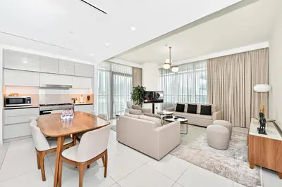 a kitchen and living room with a table and chairs at Seascape Sanctuary - 3 and a Half BR Beachfront Bliss - Marina Vista Tower 1 in Dubai