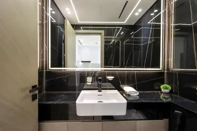 a bathroom with a white sink and a mirror at Chic 1BR in JVC with Balcony, Near Mall & Parks in Dubai