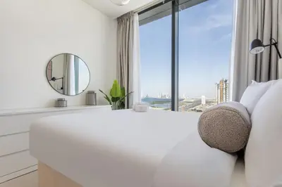 a white bedroom with a large window at STAY BY LATINEM Luxury 2BR Holiday Home W3104 near Burj Khalifa in Dubai