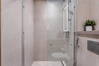 a shower with a glass door in a bathroom at STAY BY LATINEM Luxury 2BR Holiday Home W3104 near Burj Khalifa in Dubai