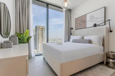 a bedroom with a large white bed and a large window at STAY BY LATINEM Luxury 2BR Holiday Home W3104 near Burj Khalifa in Dubai