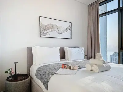 a bedroom with a large white bed with a window at Lux 1BR Apartment with Amazing view in Palace Residences Creek Harbor in Dubai