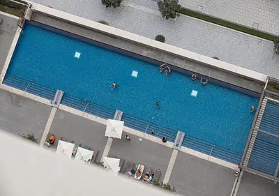 an overhead view of a large swimming pool with people in it at Lux 1BR Apartment with Amazing view in Palace Residences Creek Harbor in Dubai