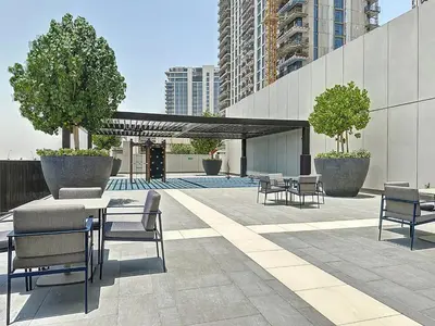 a patio with chairs and a table and ailion at Lux 1BR Apartment with Amazing view in Palace Residences Creek Harbor in Dubai
