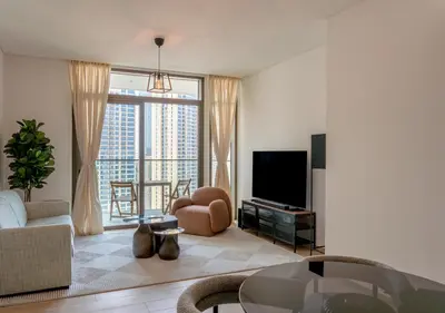 a living room with a couch and a tv at Lux 1BR Apartment with Amazing view in Palace Residences Creek Harbor in Dubai