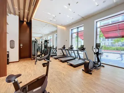 a gym with treadmills and elliptical machines at Vida Residences at Creek Beach - Light Two Bedroom in Dubai