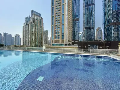 a large swimming pool in a city with tall buildings at MAG 218 Tower - Elegant One Bedroom in Dubai