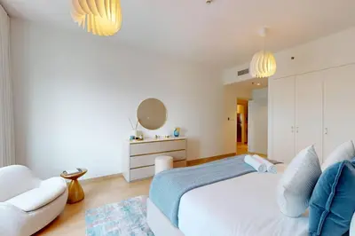 a bedroom with a white bed and a couch at MAG 218 Tower - Elegant One Bedroom in Dubai