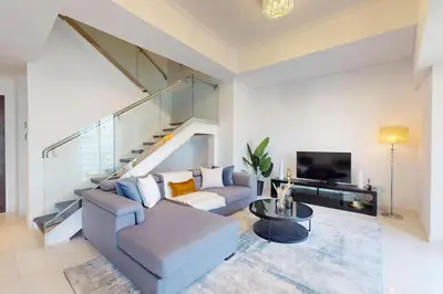 a living room with a couch and a table at Cayan Tower - Smart One Bedroom Loft on High Floor in Dubai
