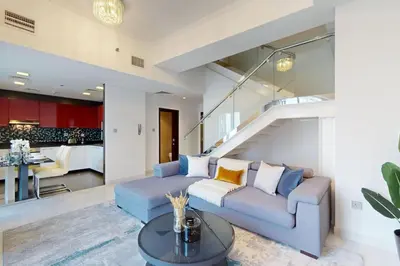 a living room with a couch and a table at Cayan Tower - Smart One Bedroom Loft on High Floor in Dubai