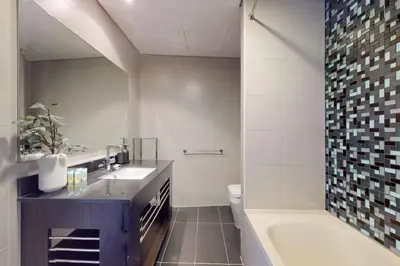 a bathroom with a tub and a toilet and a sink at Cayan Tower - Smart One Bedroom Loft on High Floor in Dubai