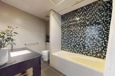 a bathroom with a tub and a sink and a toilet at Cayan Tower - Smart One Bedroom Loft on High Floor in Dubai