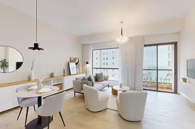 a white living room with a table and chairs at Vacationer I Premium 1 Bed I Steps to JBR Beach & Nightlife I Bahar 6 Tower in Dubai