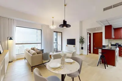 a living room with a table and chairs and a kitchen at Vacationer I Premium 1 Bed I Steps to JBR Beach & Nightlife I Bahar 6 Tower in Dubai