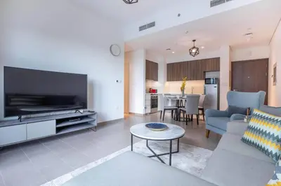 a living room with a couch and a tv and a table at 1BR Apartment in Park Heights 2 Dubai Hills in Dubai