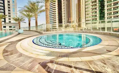 a large swimming pool in a city with tall buildings at Spacious 1BR in the iconic Torch Tower, Dubai Marina - Allsopp&Allsopp in Dubai