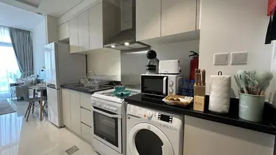 a kitchen with a washing machine and a microwave at EasyGo - Carson Tower C Damac Hills Studio in Dubai