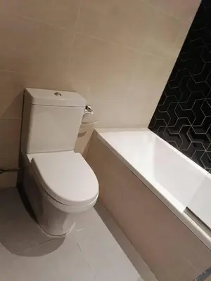 a bathroom with a white toilet and a bath tub at Luxury Studio Apartment By DownTown in Dubai