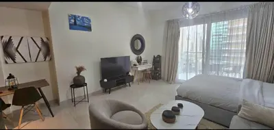 a living room with a bed and a television at Luxury Studio Apartment By DownTown in Dubai