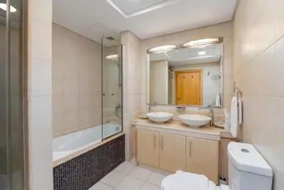 a bathroom with two sinks and a tub and a toilet at Shoreline 7, Palm Jumeirah - Mint Stay in Dubai