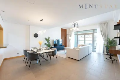 a living room with a table and a white couch at Shoreline 7, Palm Jumeirah - Mint Stay in Dubai