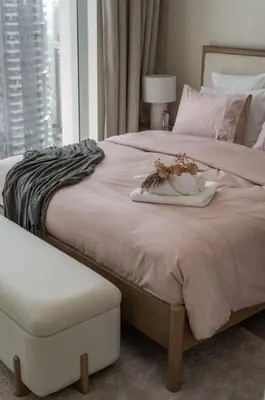 a bed with a bowl of flowers on top of it at 4BR - Burj and Fountain View - Opposite Dubai Mall in Dubai