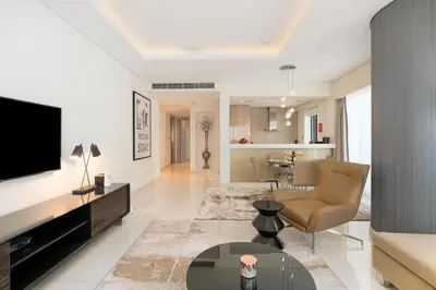 a living room with a television and a couch and a table at Damac Paramount - Luxurious 2BR - Stunning Dubai Canal View - High Level in Dubai