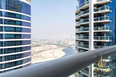 a view of a beach between two tall buildings at Damac Paramount - Luxurious 2BR - Stunning Dubai Canal View - High Level in Dubai