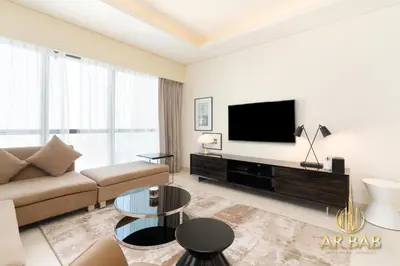 a living room with a couch and a flat screen tv at Damac Paramount - Luxurious 2BR - Stunning Dubai Canal View - High Level in Dubai