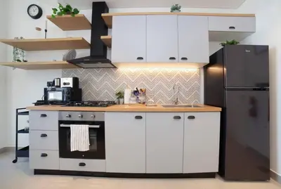 a kitchen with white cabinets and a black refrigerator at Dubai Hills Collective Tower 2 in Dubai