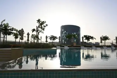 a swimming pool with a fountain in front of a building at Dubai Hills Collective Tower 2 in Dubai